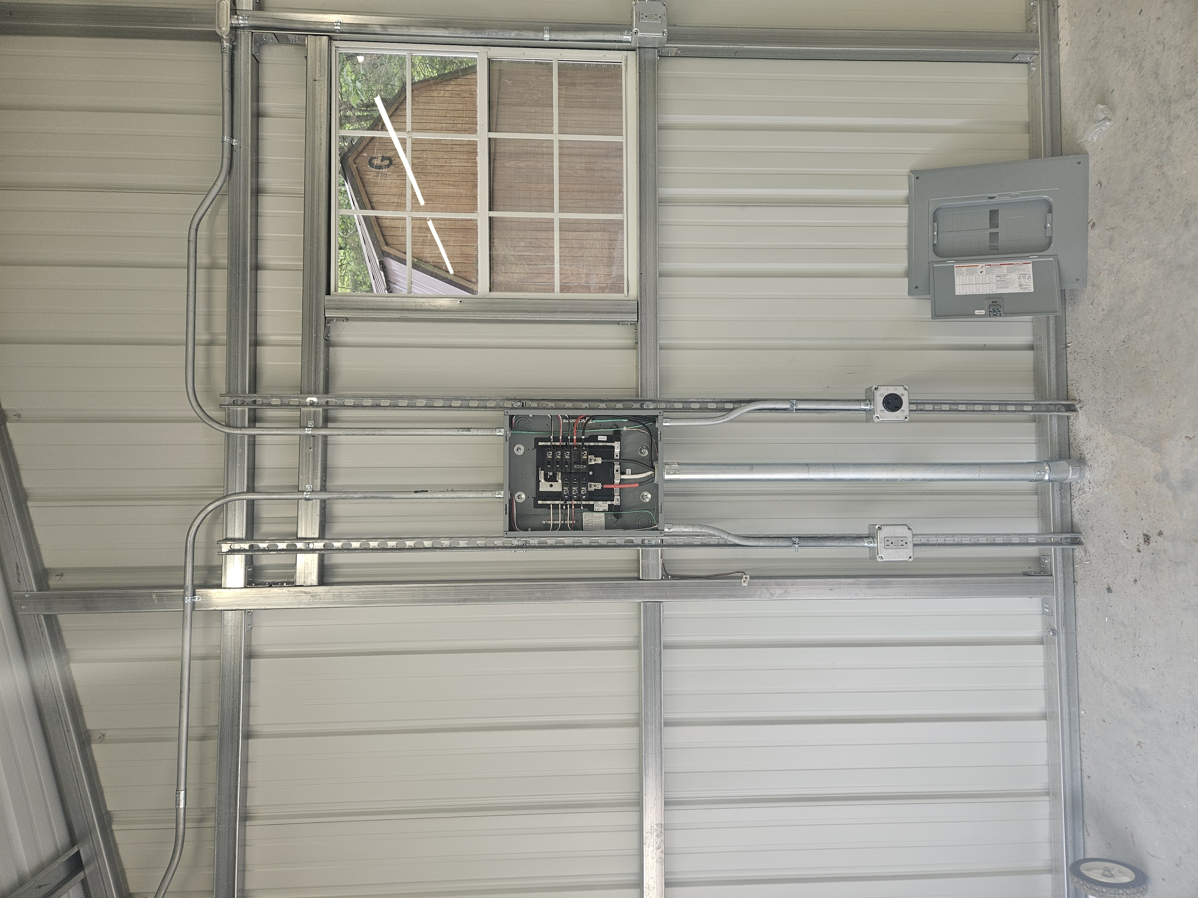 Electrical panel with outlets and conduit in a metal outbuilding